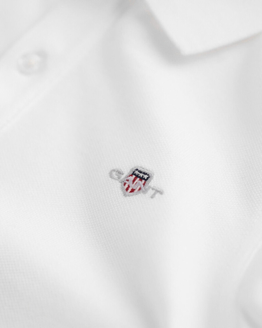 kinder-piqué-poloshirt mit schildmuster – weiß